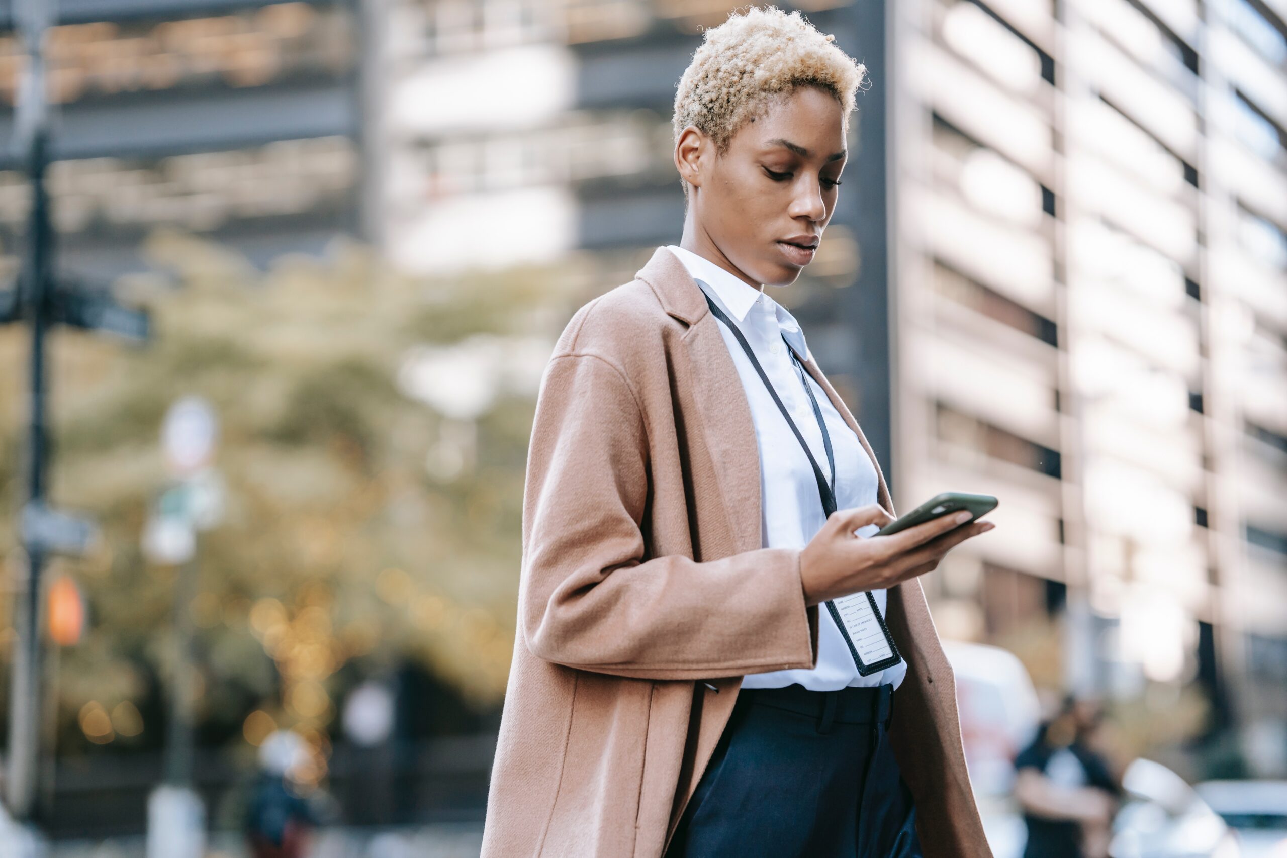 Professional woman using her phone on city street